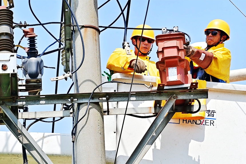 國網豐城市供電公司帶電作業人員進行高空作業，滿足企業用電需求。李意攝
