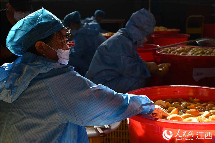 工人們正在清洗并為黃桃去核。賴漢晨攝