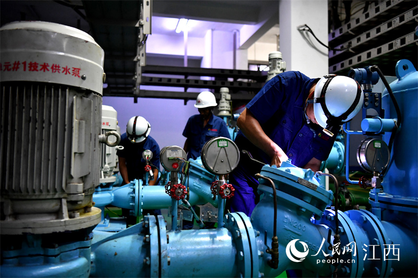 電站設備間內，工作人員正在對機械進行檢修。 人民網 時雨攝