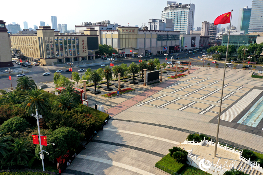 八一廣場飄揚的國旗與八一大道上懸掛的國旗相互襯托。 人民網 時雨攝