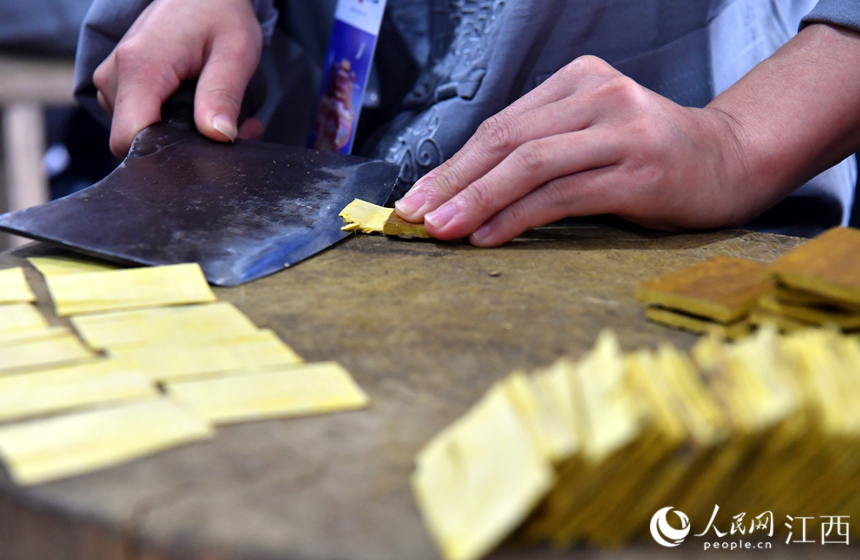 在樟樹岐黃小鎮里，藥工正在進行樟幫中藥炮制技藝展演。 人民網 時雨攝