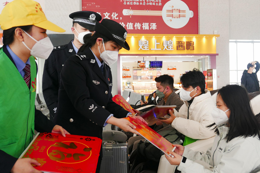 為營造節日氛圍，車站鐵路公安和鐵路志愿者為旅客送去新春祝福。倪述群攝