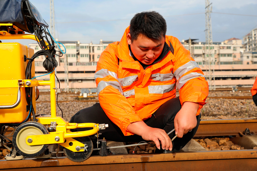 通過手工與儀器相結合方式，協助執機人進行鋼軌傷損的復核工作。陳霏滸攝