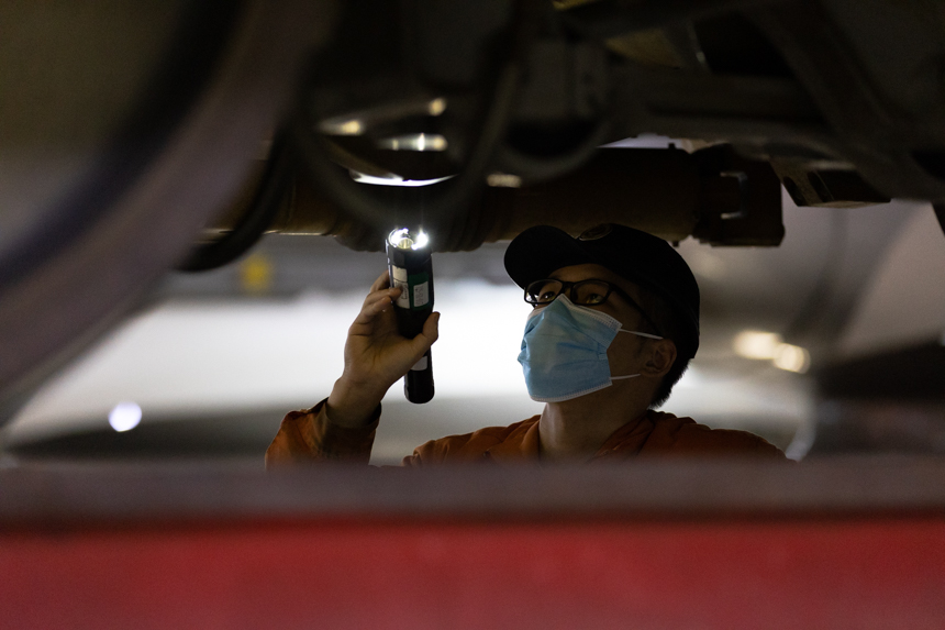 一名動車組機械師正在半蹲著對動車組車底進行檢查。李桐 攝