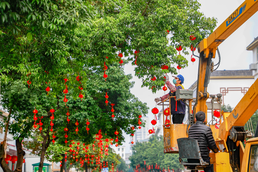市政工人在江西省贛州市全南縣城區街道懸掛紅燈籠。李凡欽攝