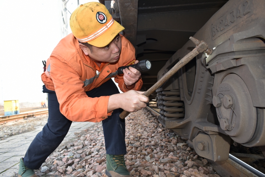 檢車員肖雪峰正在檢查車輛轉向架技術狀態。付順明攝