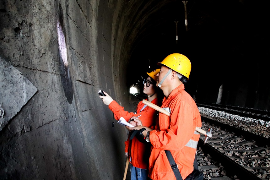 女橋隧工何卓卿與父親在隧道內排查隧道漏水等病害。羅毅攝