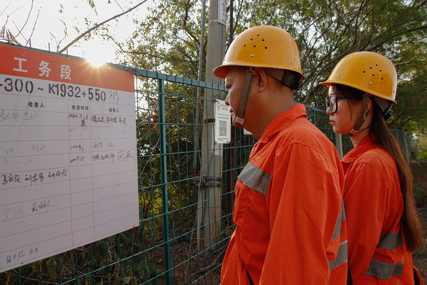 女橋隧工何卓卿與父親檢查K1932+500防洪重點地段。羅毅攝