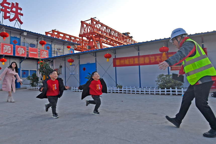 陳南生下班回來，雙胞胎兒子興奮地撲向他的懷抱。 劉凱攝