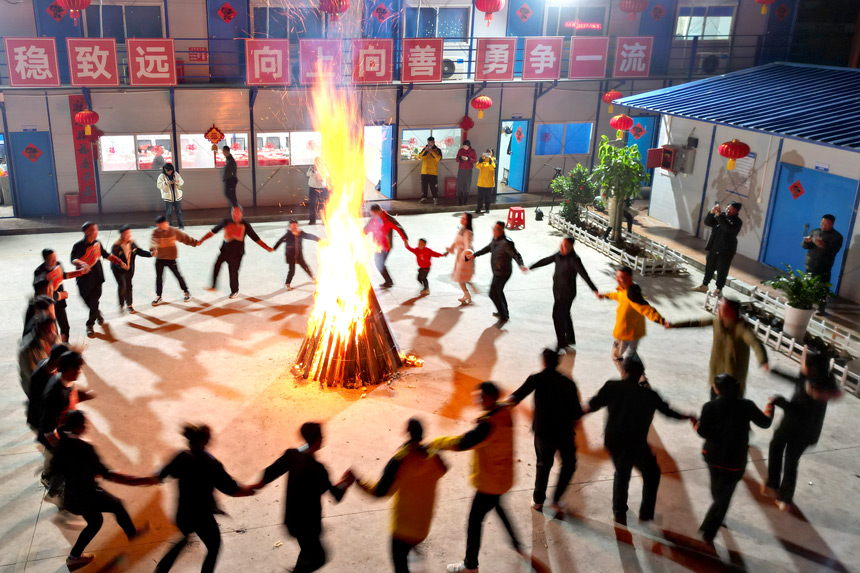 篝火晚會上，陳南生一家和其他留守工友開心地跳起民族舞。劉凱攝