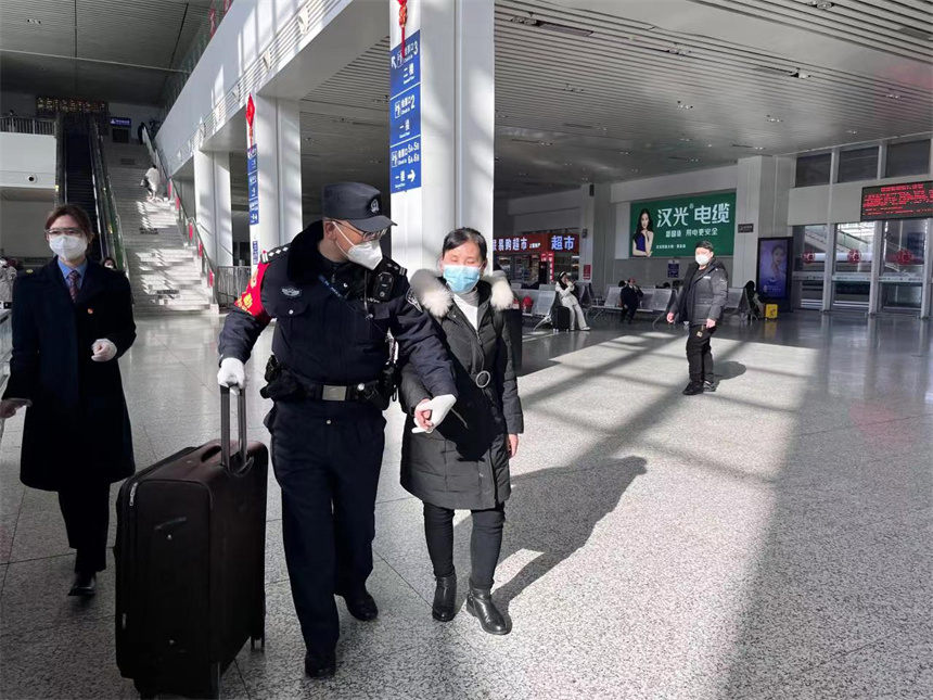 民警李建軍幫助盲人旅客進站乘車。王夢怡攝