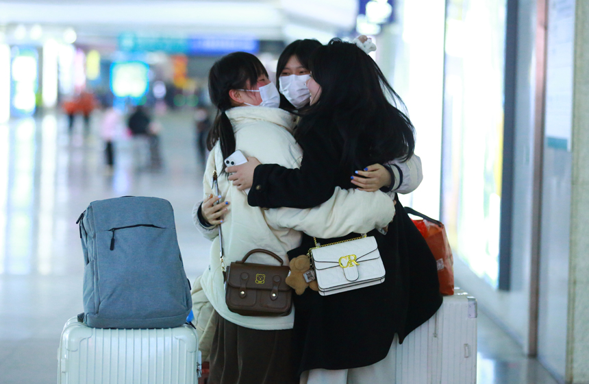 在出站口相遇的小姐妹擁抱團聚，洋溢著開心的笑容。陸瑤攝