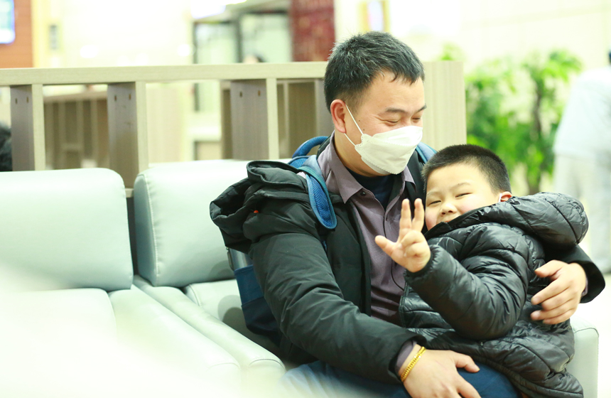 父親懷抱著孩子候車。陸瑤攝