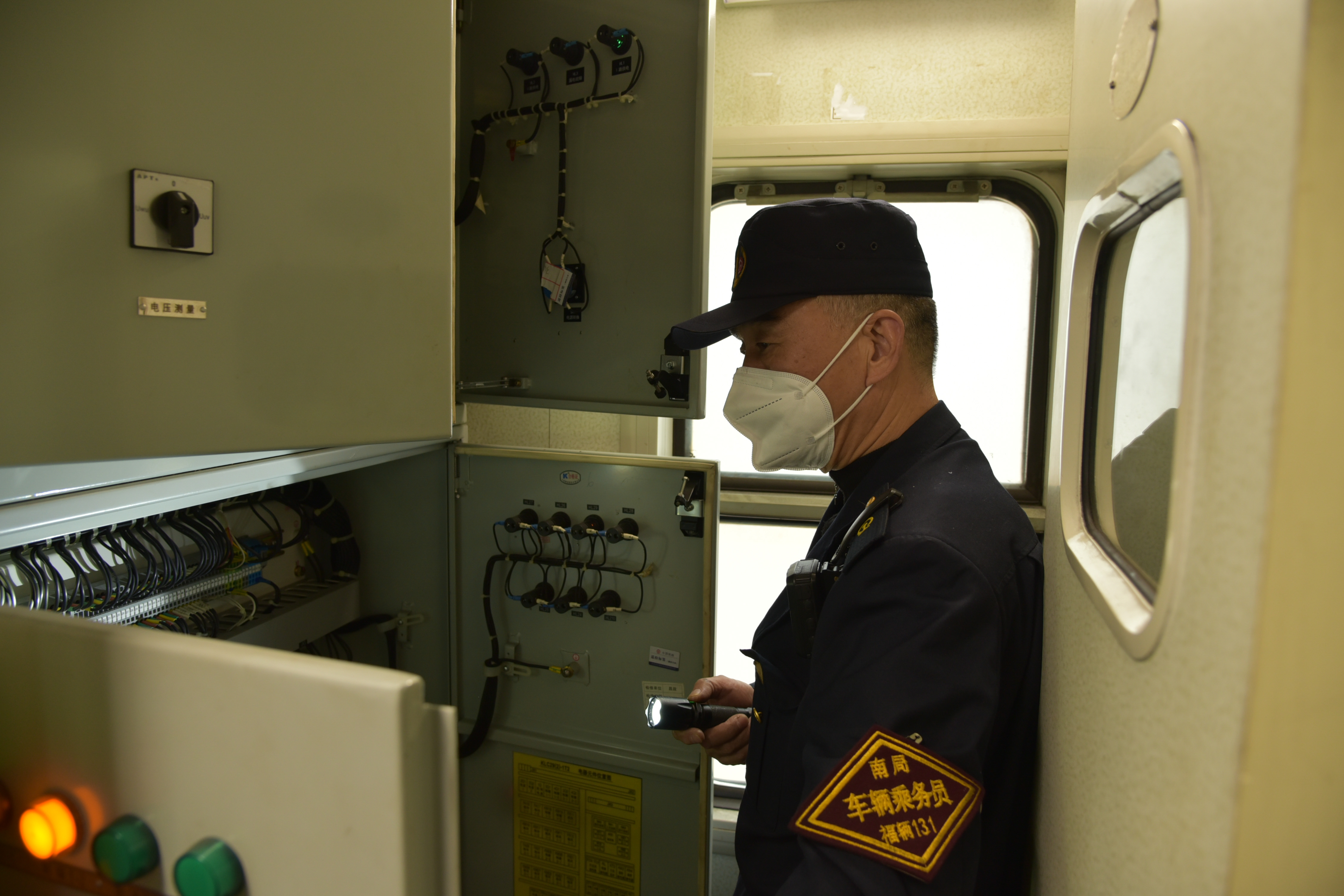 梁建雄正在檢查車輛配電柜。劉斌攝