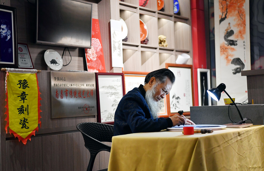 在“非遺匠心館”的工作室內，李強正在刻瓷。 人民網 時雨攝