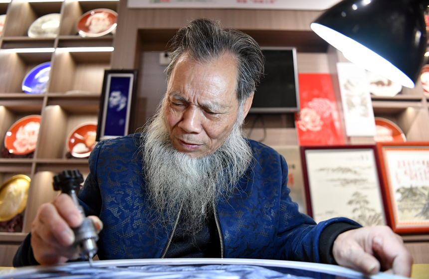 在“非遺匠心館”的工作室內，李強正在刻瓷。 人民網 時雨攝