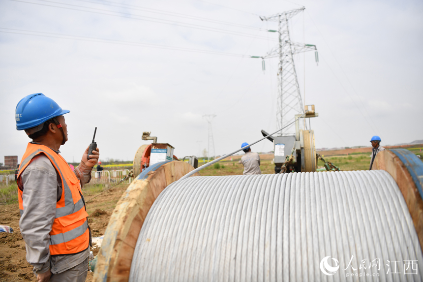電網工作人員正在地面密切關注電塔牽線動態。人民網 時雨攝