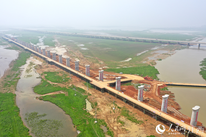 湖中已建成的高鐵橋墩與不遠處的快速路遙相呼應。 人民網 時雨攝
