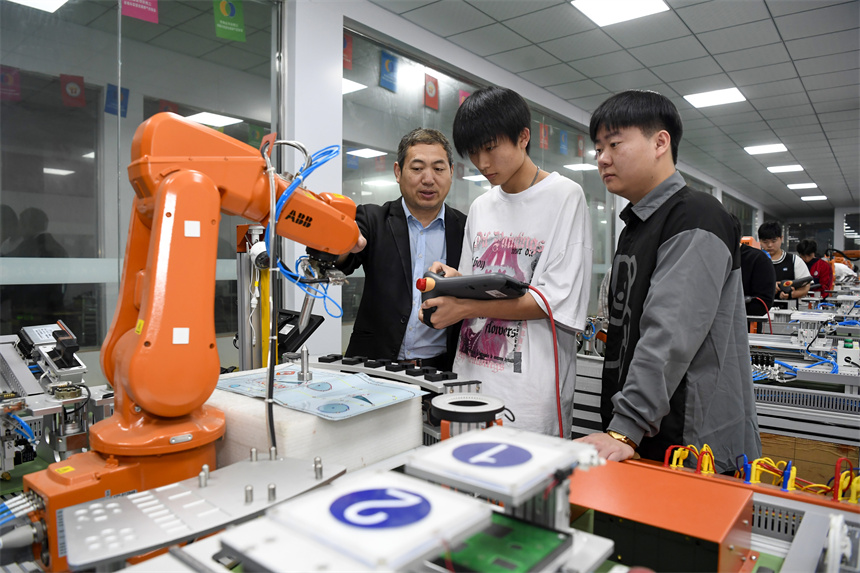 學生在老師的指導下進行工業機器人的操作實訓。周亮攝