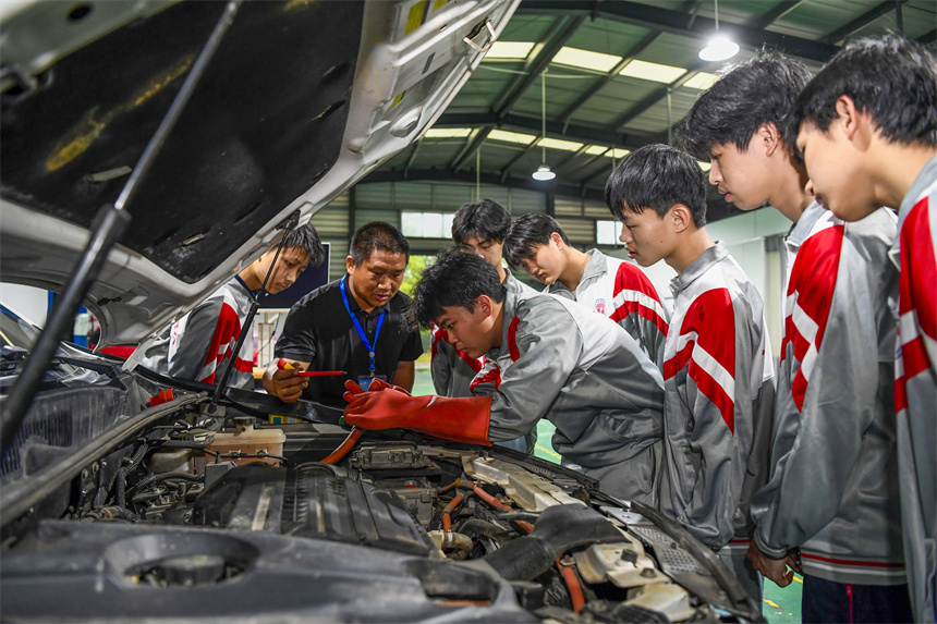 學生在老師的指導下進行新能源汽車維修實訓。周亮攝