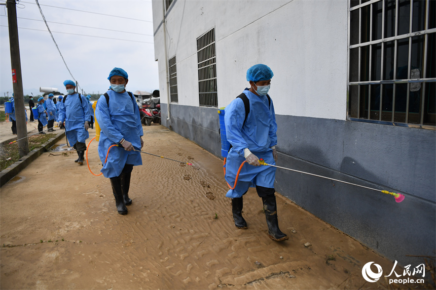 退水后，防疫人員正在消殺。 人民網記者 時雨攝