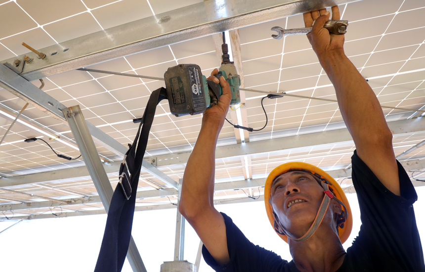 施工人員在光伏電板安裝現場忙碌。何賤來攝