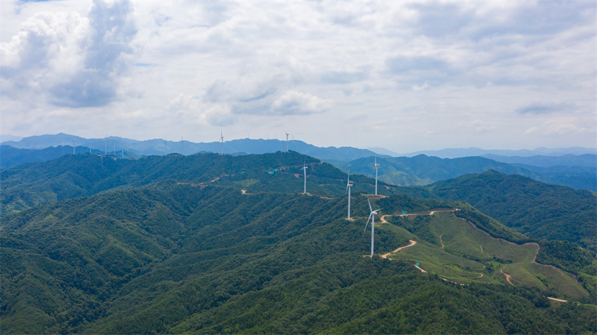 一臺臺風力發電機矗立在群山之巔，美不勝收。李凡欽攝