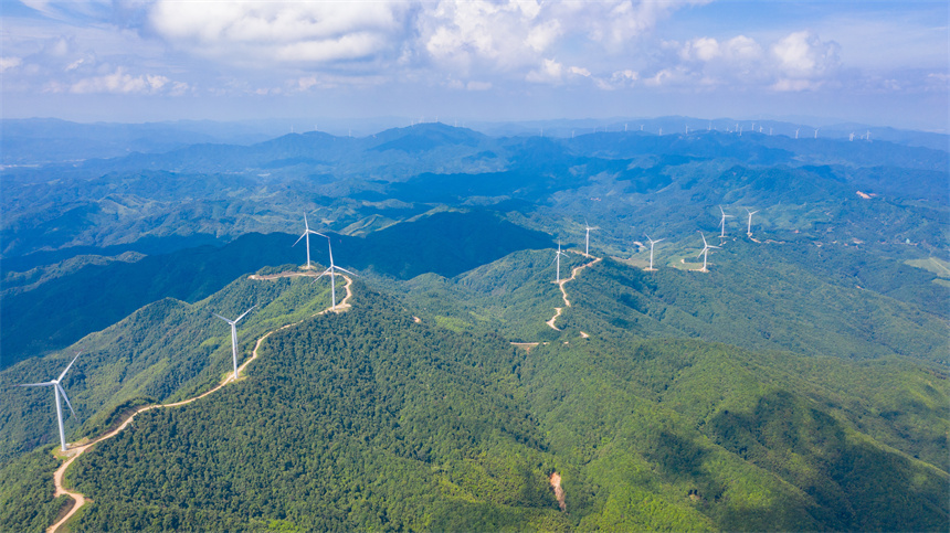 一臺臺風力發電機矗立在群山之巔，美不勝收。李凡欽攝