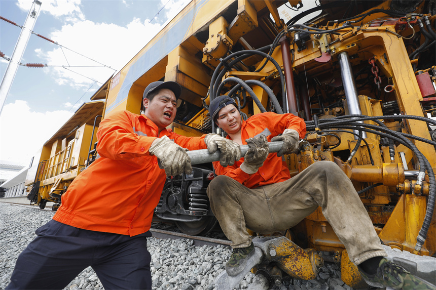 人們頂著高溫加緊對設備進行養護。汪翰攝