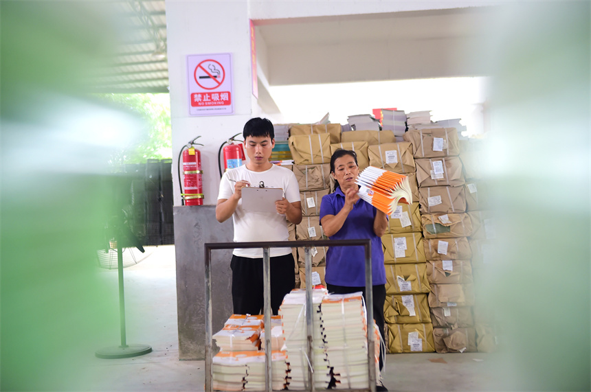 工作人員在課本倉庫內清點、分發2023年秋學期教材和教輔資料。呂春華攝