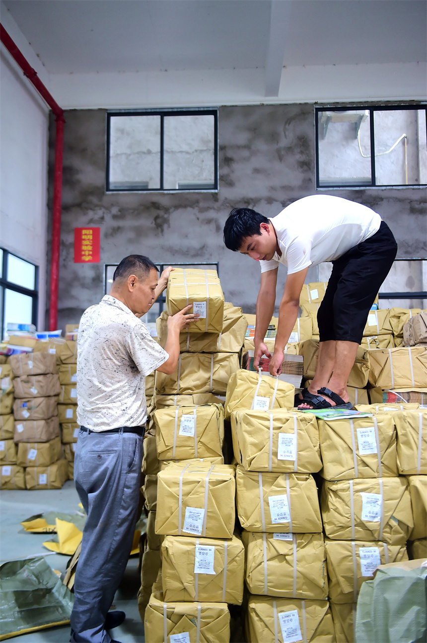 工作人員在課本倉庫內清點、分發2023年秋學期教材和教輔資料。呂春華攝
