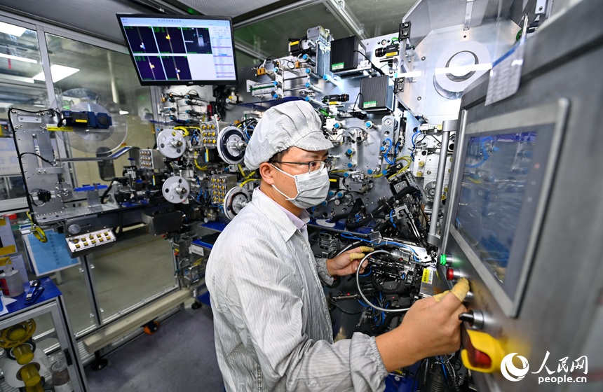 近日，鋰電新能源電池生產企業內，工人在操作電子設備趕制電池產品訂單。人民網 朱海鵬攝