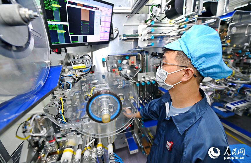 近日，鋰電新能源電池生產企業內，工人在操作電子設備趕制電池產品訂單。人民網 朱海鵬攝