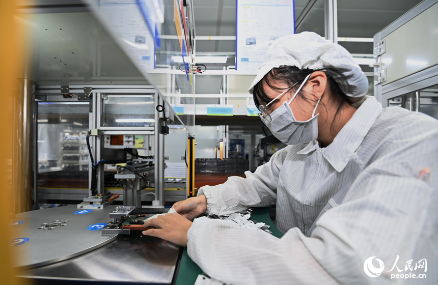 近日，鋰電新能源電池生產企業內，工人在操作電子設備趕制電池產品訂單。人民網 朱海鵬攝