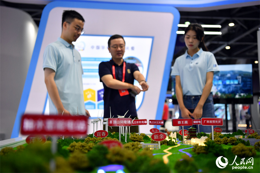 參展商在展位的沙盤模型旁介紹企業在新能源方面的產品。 人民網記者 時雨攝