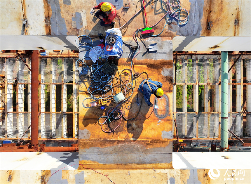 工人忙著安裝架設鋼結構件。人民網 朱海鵬攝