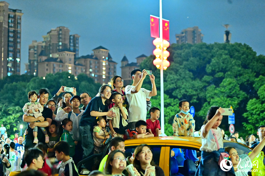 10月1日晚，絢爛多彩的煙花在贛江兩岸閃耀，游客競相觀看拍照留念。人民網 朱海鵬攝