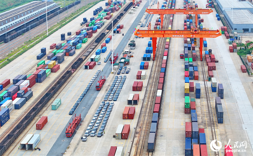 大型吊裝設備在裝運出口的國產電動載人汽車。人民網 朱海鵬攝