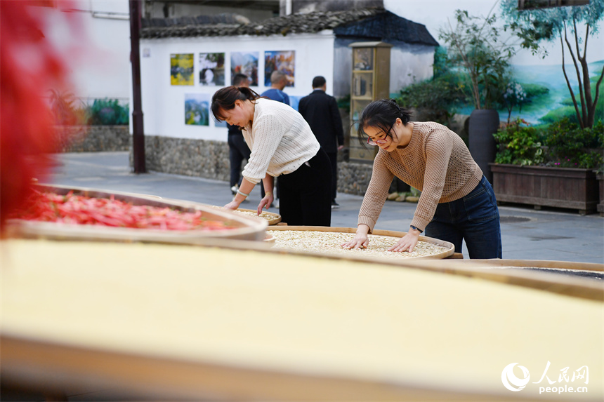 村民正在翻曬曬匾上的農作物。 人民網記者 時雨攝