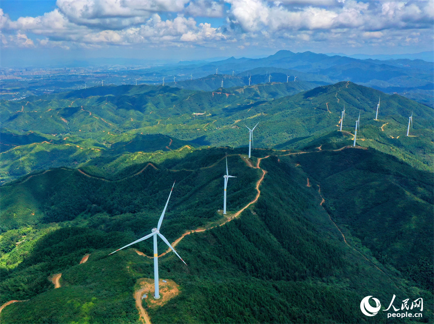 一臺臺安裝好的風力發電機組矗立在綿延群山上。人民網 朱海鵬攝