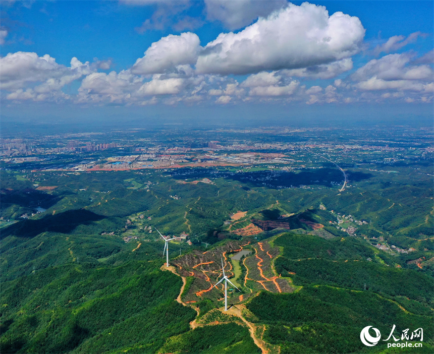 一臺臺安裝好的風力發電機組矗立在綿延群山上。人民網 朱海鵬攝