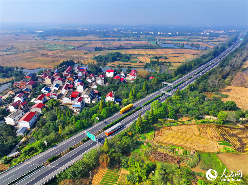 近日，江西省南昌市南昌縣岡上鎮安仁村，滬昆高速公路穿境而過，沿線鱗次櫛比的農房與稻田、水系、綠樹相映襯，構成一幅深秋時節和美鄉村畫卷。人民網 朱海鵬攝