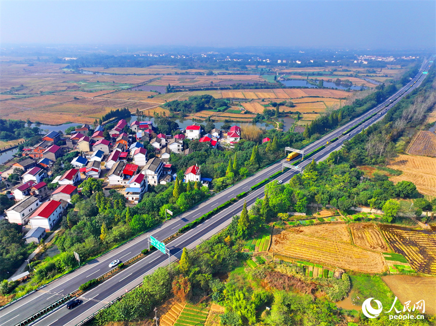 近日，江西省南昌市南昌縣岡上鎮安仁村，滬昆高速公路穿境而過，沿線鱗次櫛比的農房與稻田、水系、綠樹相映襯，構成一幅深秋時節和美鄉村畫卷。人民網 朱海鵬攝