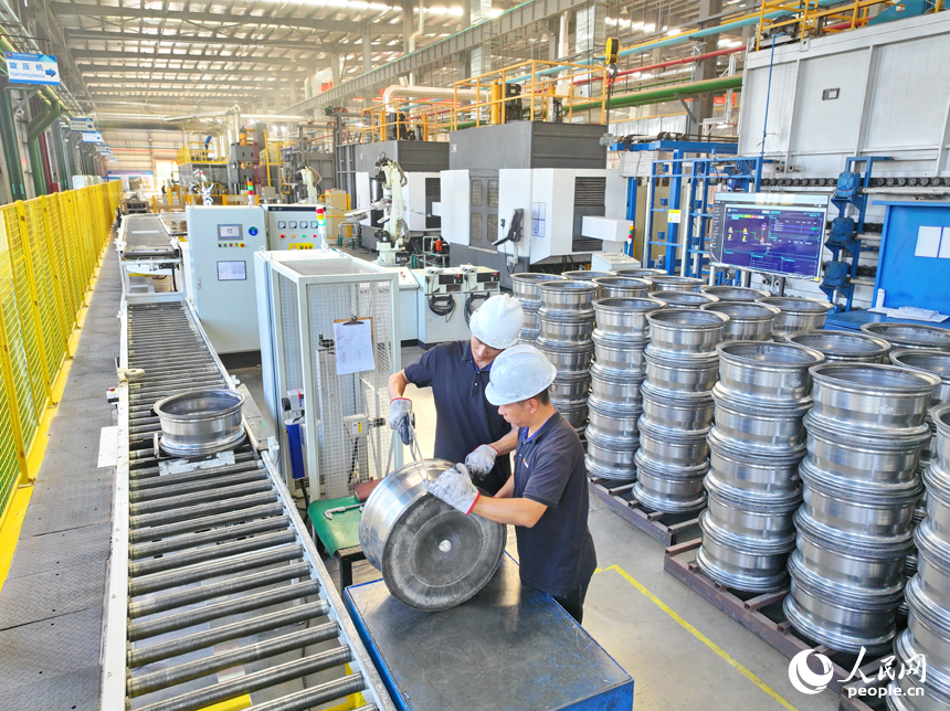 車間內，工人在操作新型智能設備趕制出口輪轂訂單產品。人民網 朱海鵬攝