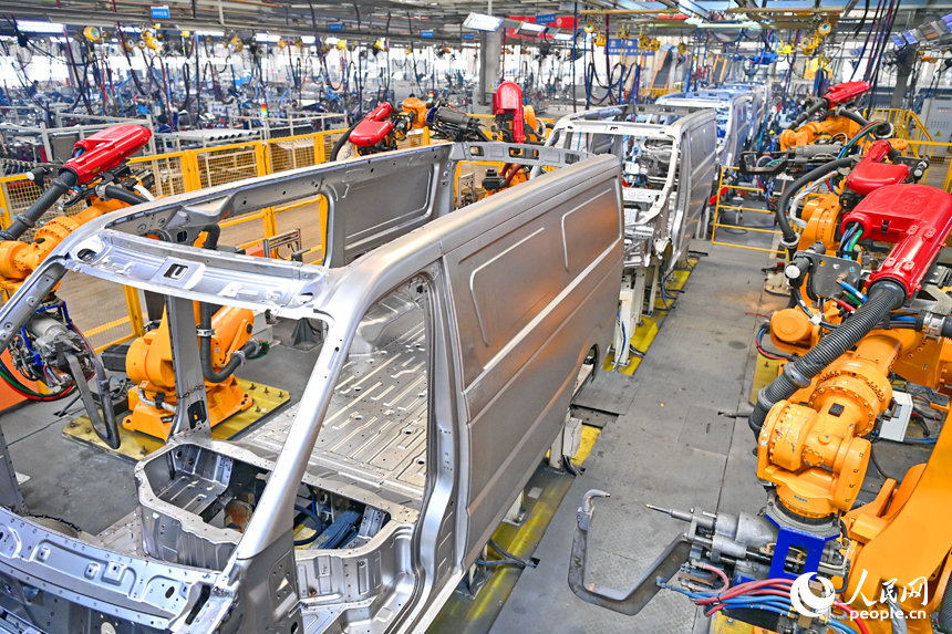 機械手臂在快速運轉，進行微型快遞運輸車車廂自動化焊接。人民網 朱海鵬攝