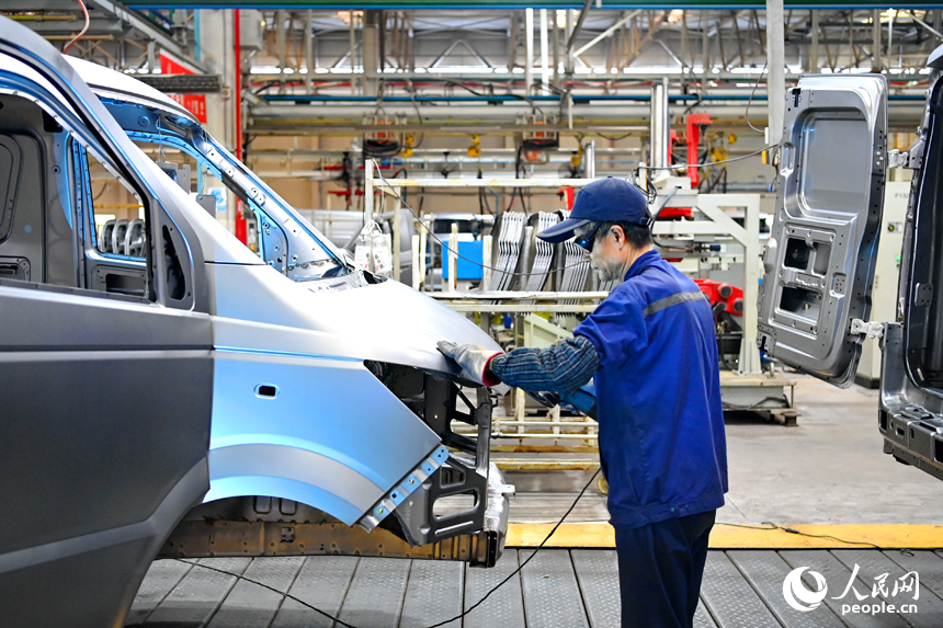 工人在給微型快遞運輸車車廂封膠。人民網 朱海鵬攝