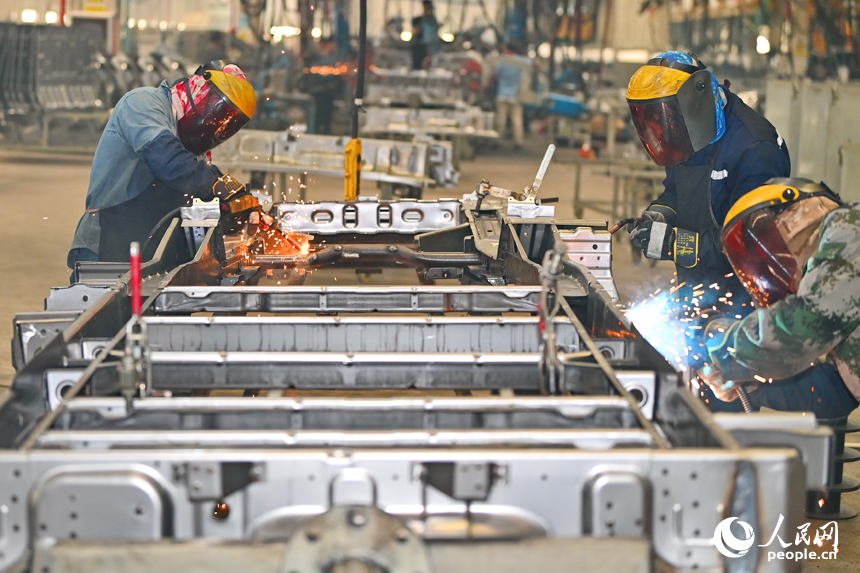 工人在趕制微型快遞運輸車，車間一片忙碌。人民網 朱海鵬攝