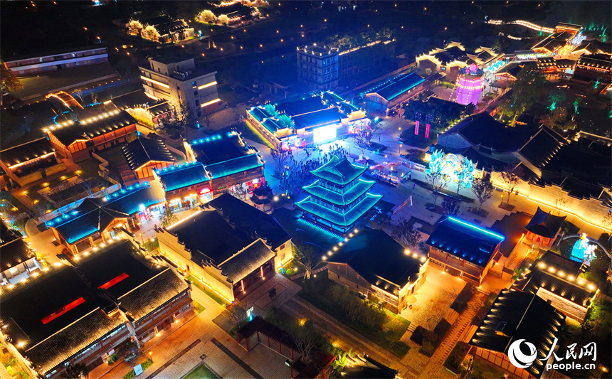 夜色中的七鯉古鎮，與遠處城市高樓大廈相輝映，古色古韻與現代氣息的交融，吸引了許多游客。人民網 朱海鵬攝