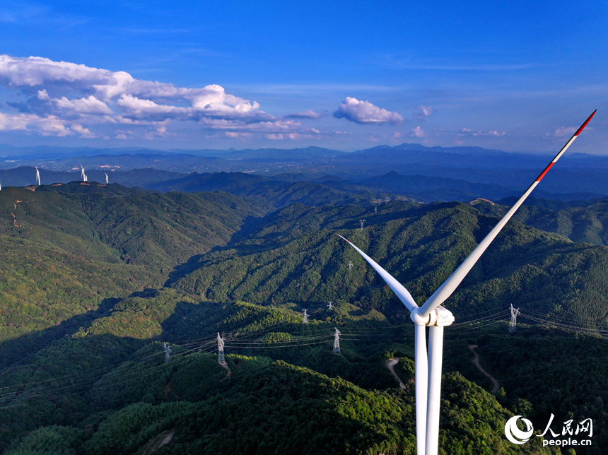 贛州市定南縣歷市鎮群山之上，風力發電機迎風旋轉，轉化為清潔電源并入電網輸往工廠企業、千家萬戶。人民網 朱海鵬攝