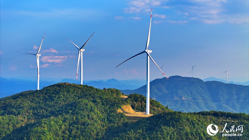贛州市定南縣歷市鎮群山之上，風力發電機迎風旋轉，轉化為清潔電源并入電網輸往工廠企業、千家萬戶。人民網 朱海鵬攝